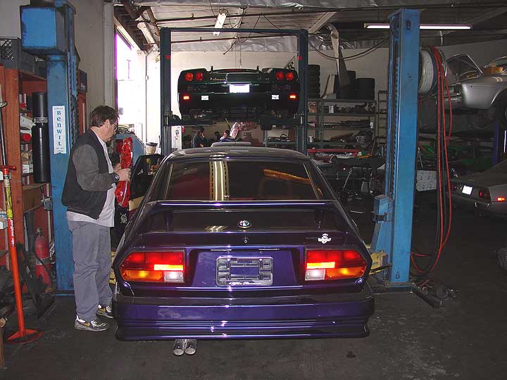 Gregg tucks a just arrived NOS part into the car with one of his twin turbo Lambo Diablos on the lift in the background.